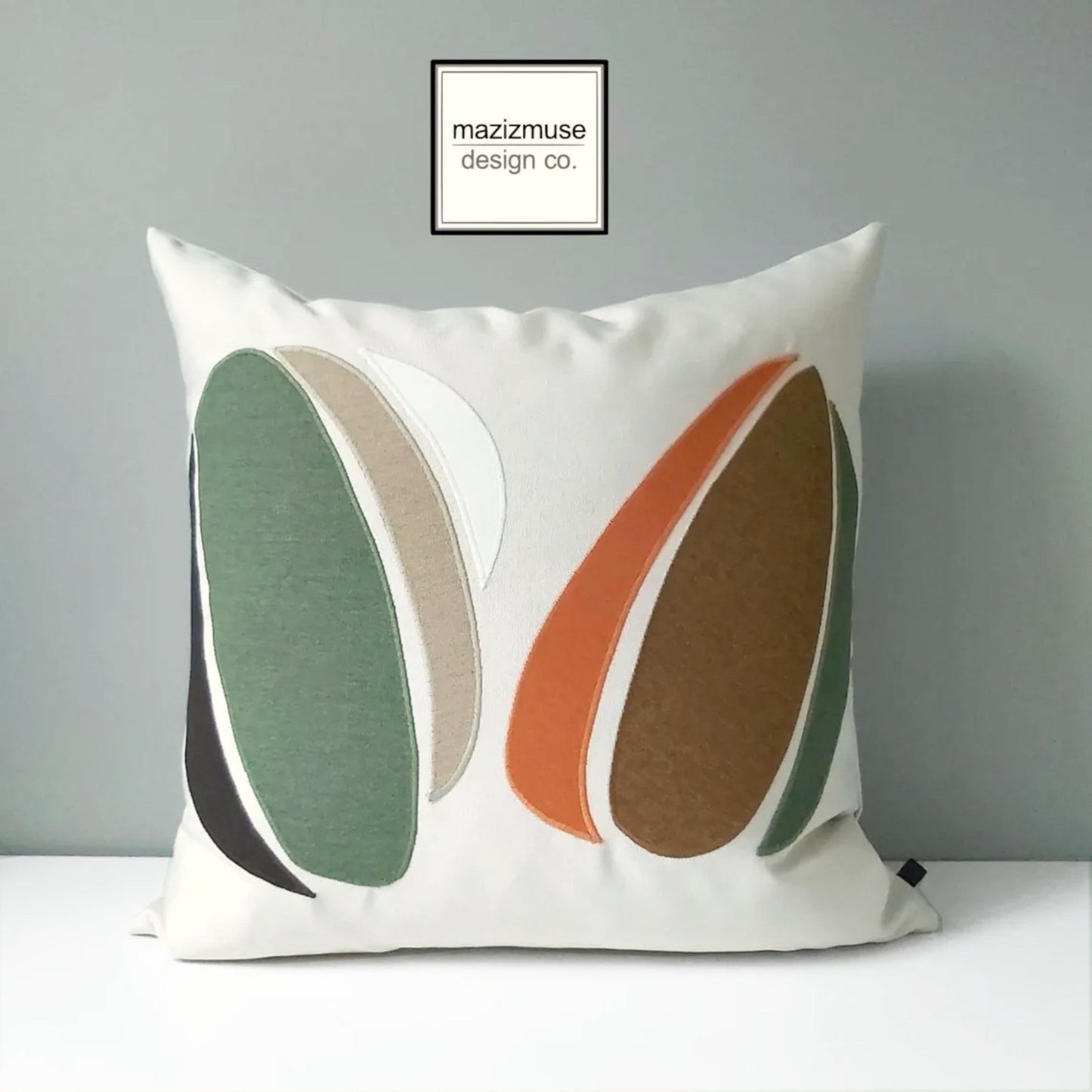 abstract sunbrella outdoor pillow with green brown rust design on creamy background by mazizmuse