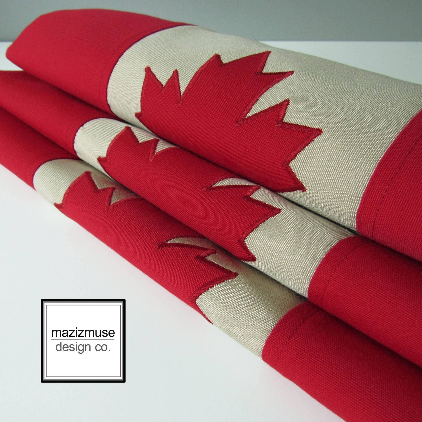 stack of three canada flag outdoor pillow covers