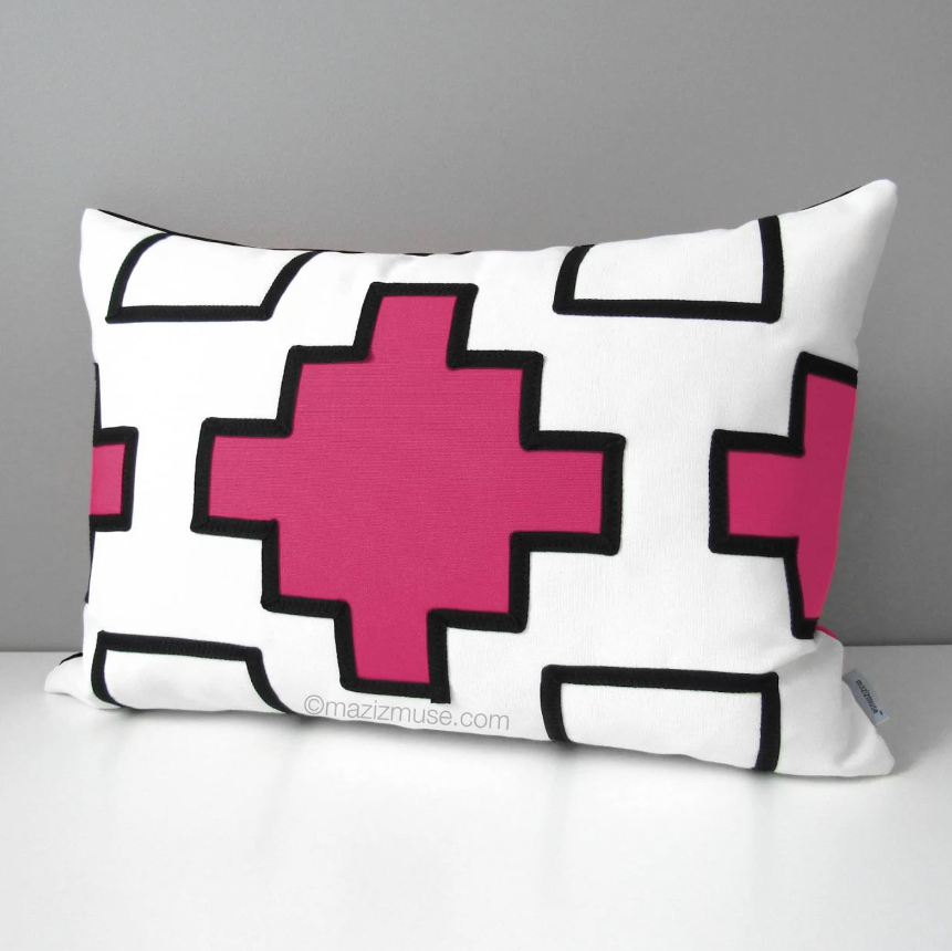 aztec inspired outdoor sunbrella pillow in hot pink and black geometric design on white.