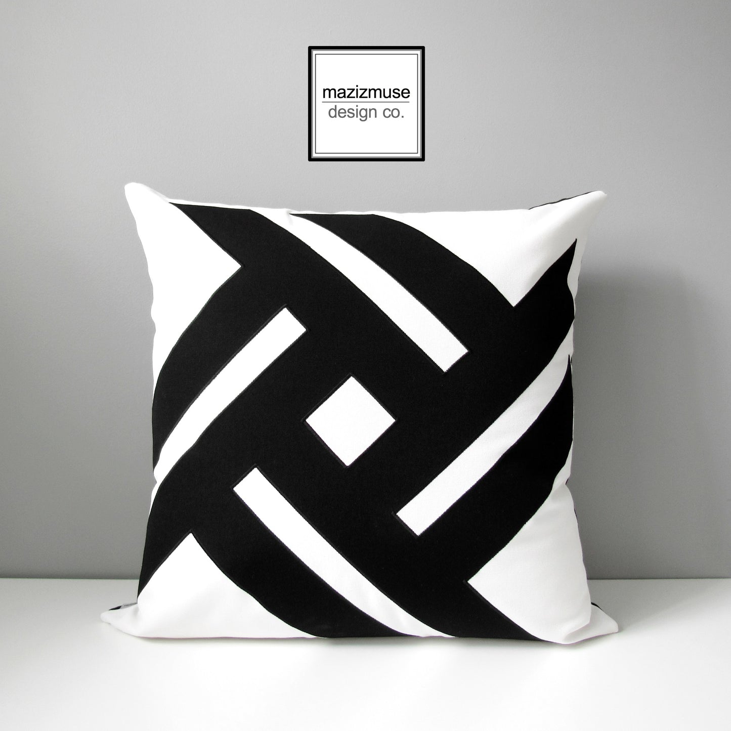 white and black geometric outdoor sunbella pillow cover with striking pinwheel design
