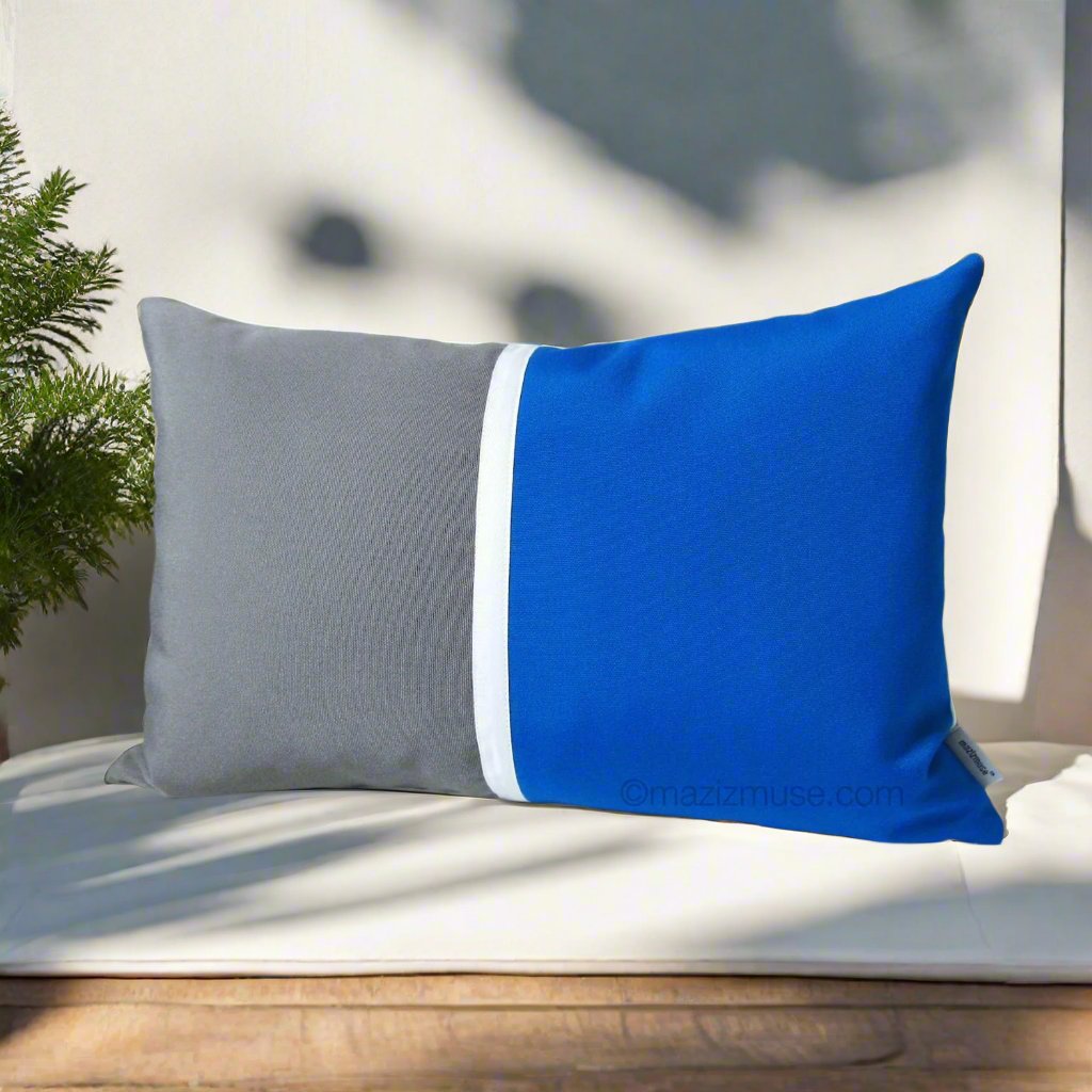 pacific blue and gray sunbrella outdoor pillow on a white bench