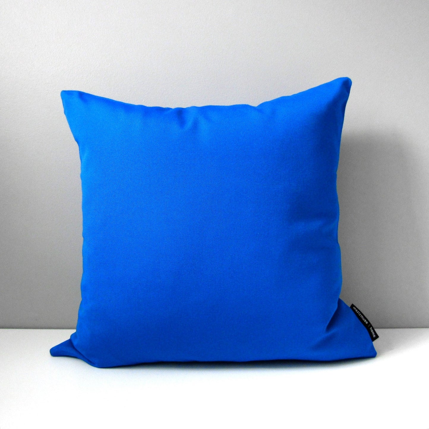 solid cobalt blue sunbrella outdoor pillow for modern patio and poolside seating