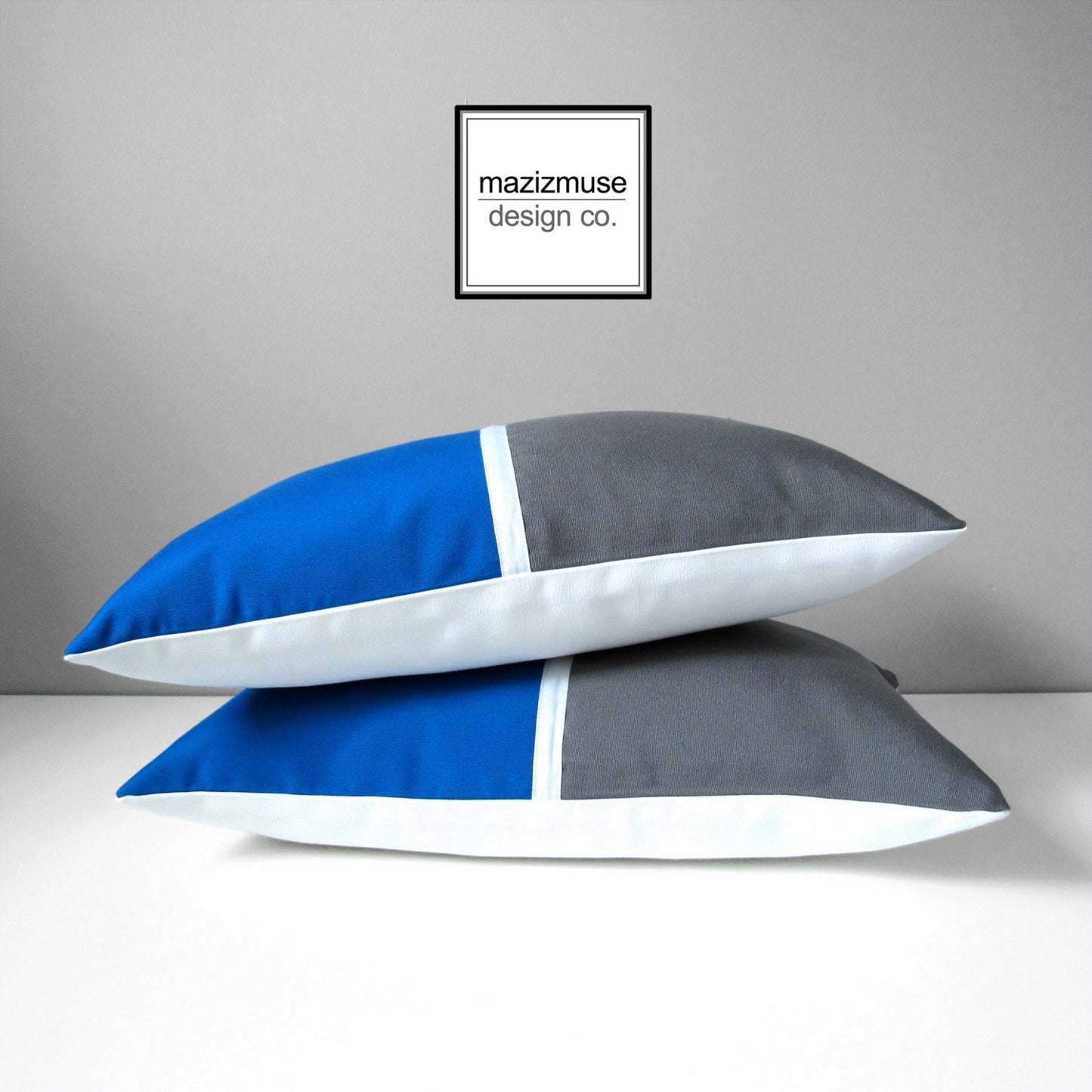 cobalt blue and grey colorblcok pillow cover in sunbrella outdoor fabric. features white trim detail in the center.