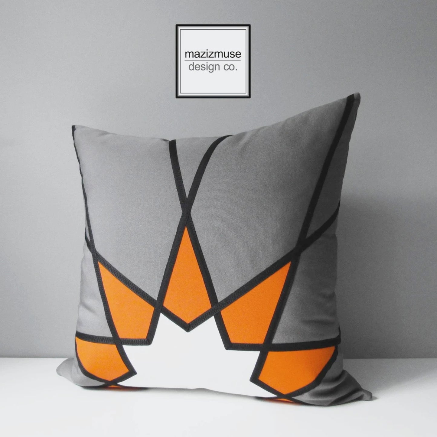 grey and orange outdoor pillow with mandala starburst design. crated from sunbrella fabric for superior fade and stain resistance. Handmade in canada by mazizmuse