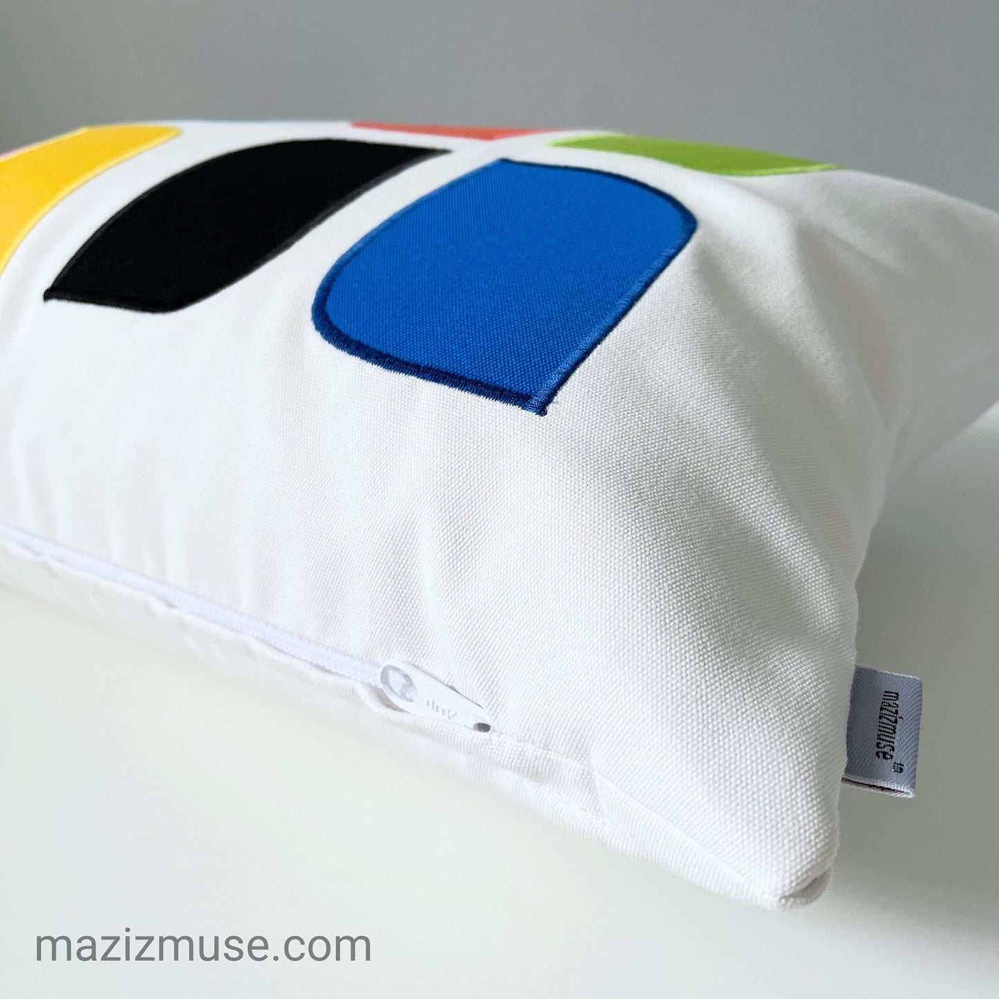 Colorful pillow with geometric patterns on a white background