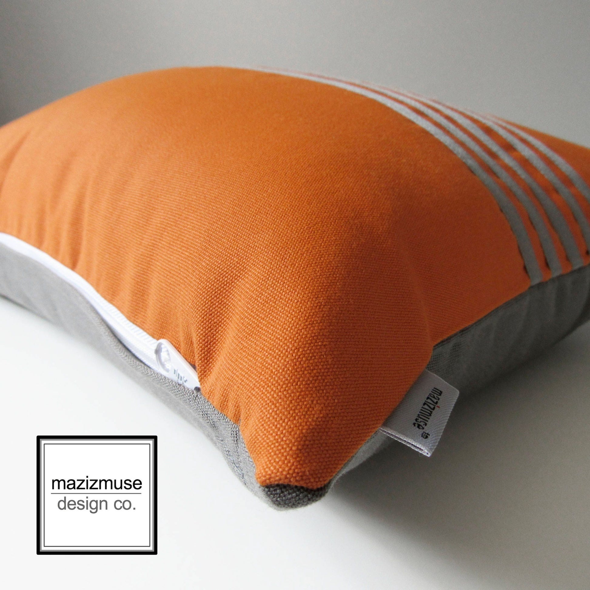 close up of orange and grey outdoor pillow showing texture of fabric and zipper